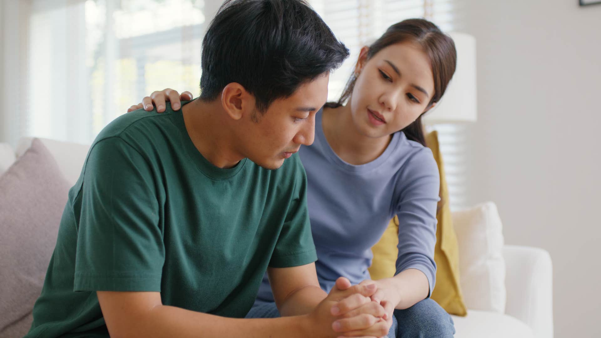 Woman who notices her partner's mood comforting him at home.