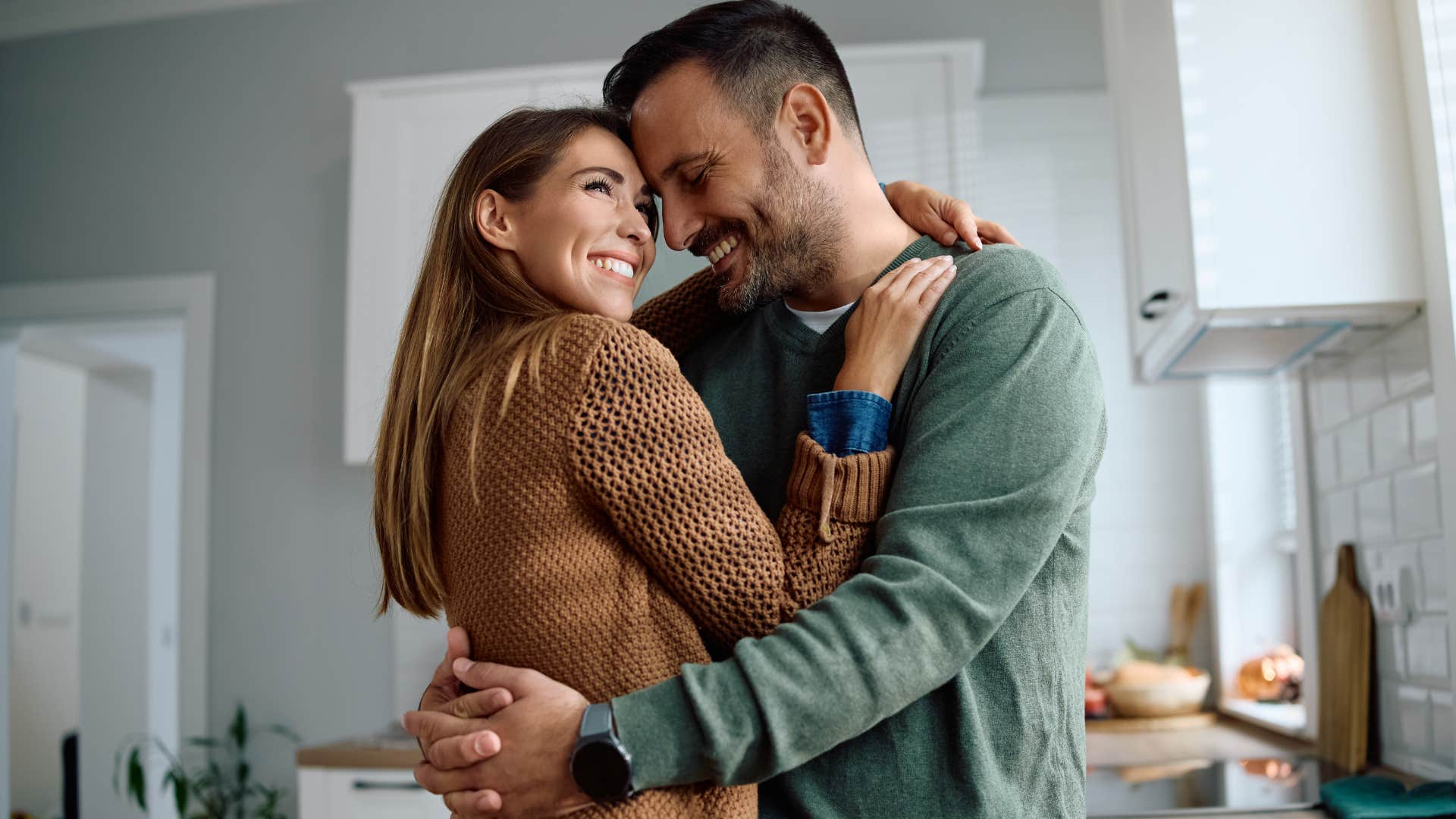 Woman who remembers the small things hugging her husband at home.