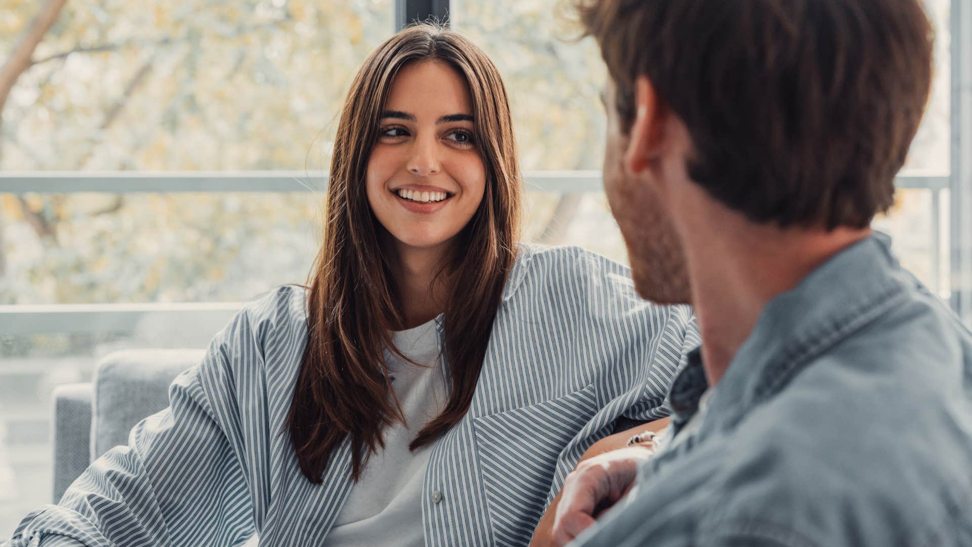 woman actively listening to and smiling at her partner