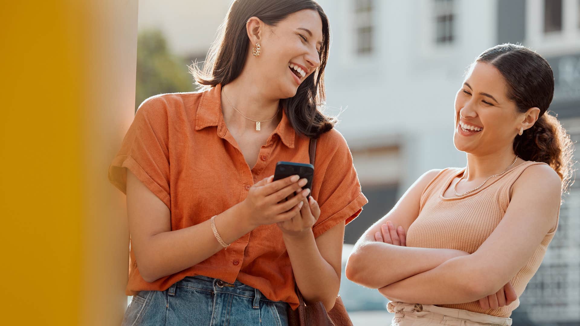 woman making the small move of texting man while she's out with friend