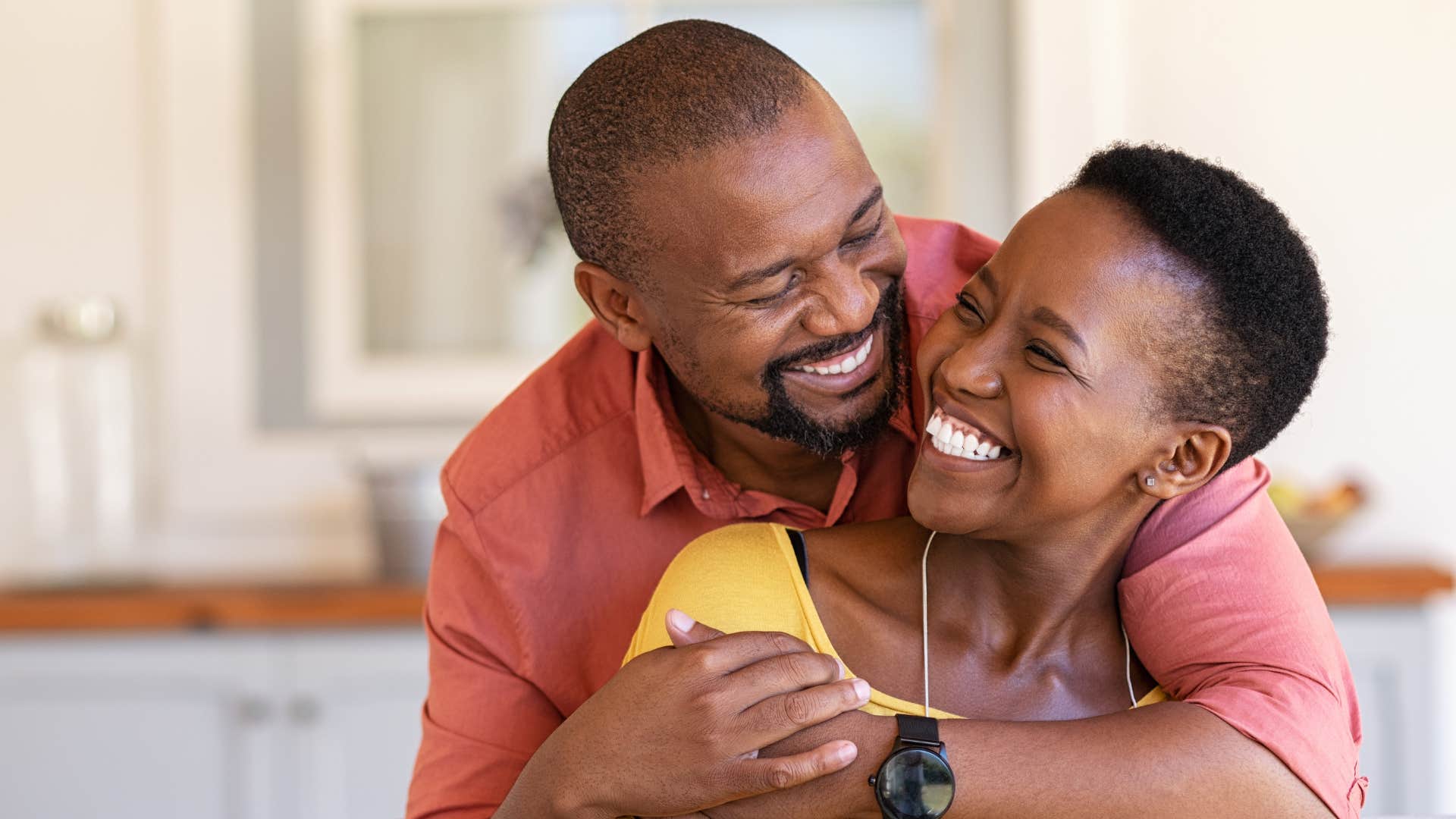 a man smiles as he knows how far his wife has grown throughout their relationship