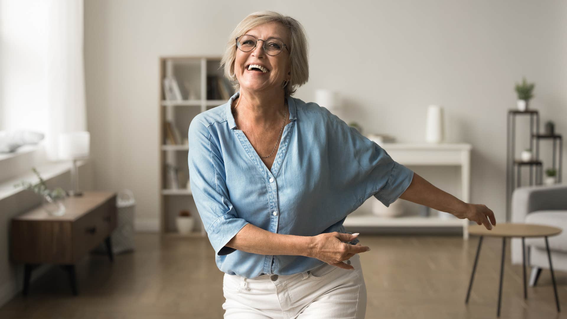 happy older woman dancing spontaneously at home