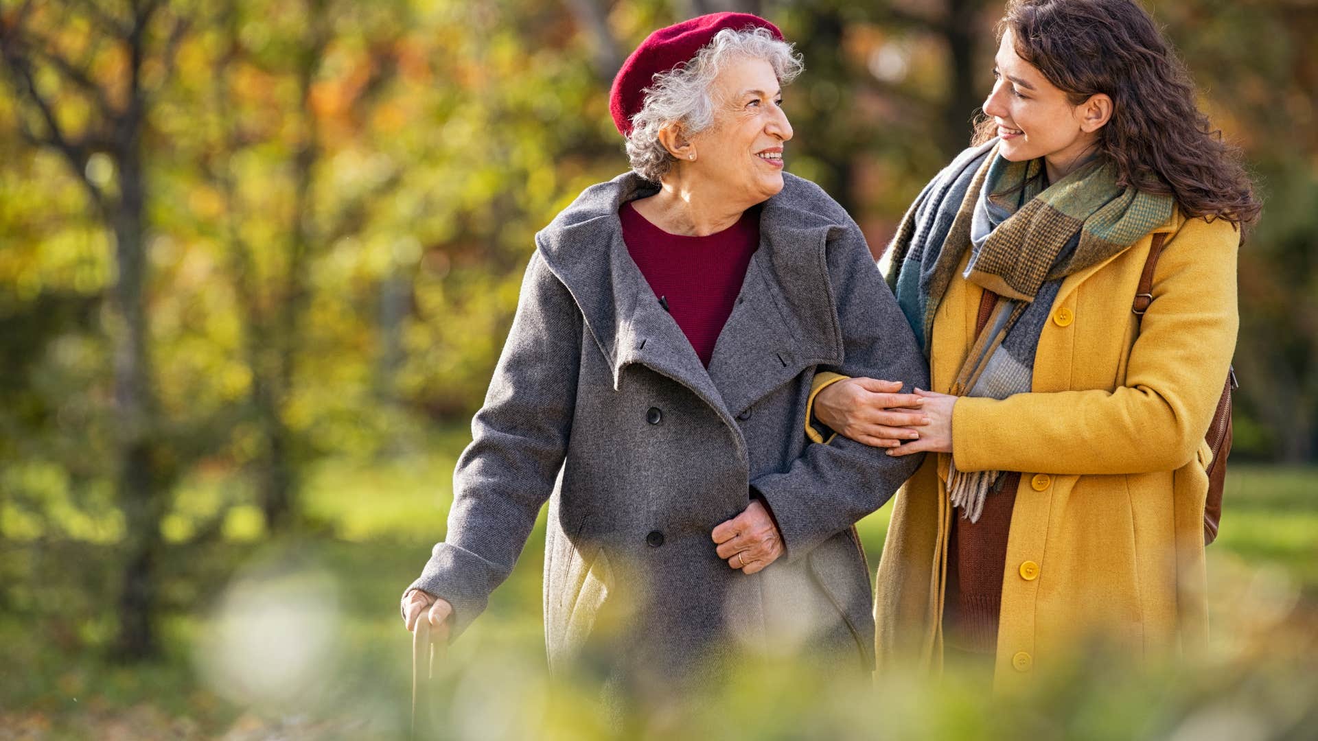 happy woman performing small act of kindness helping older woman