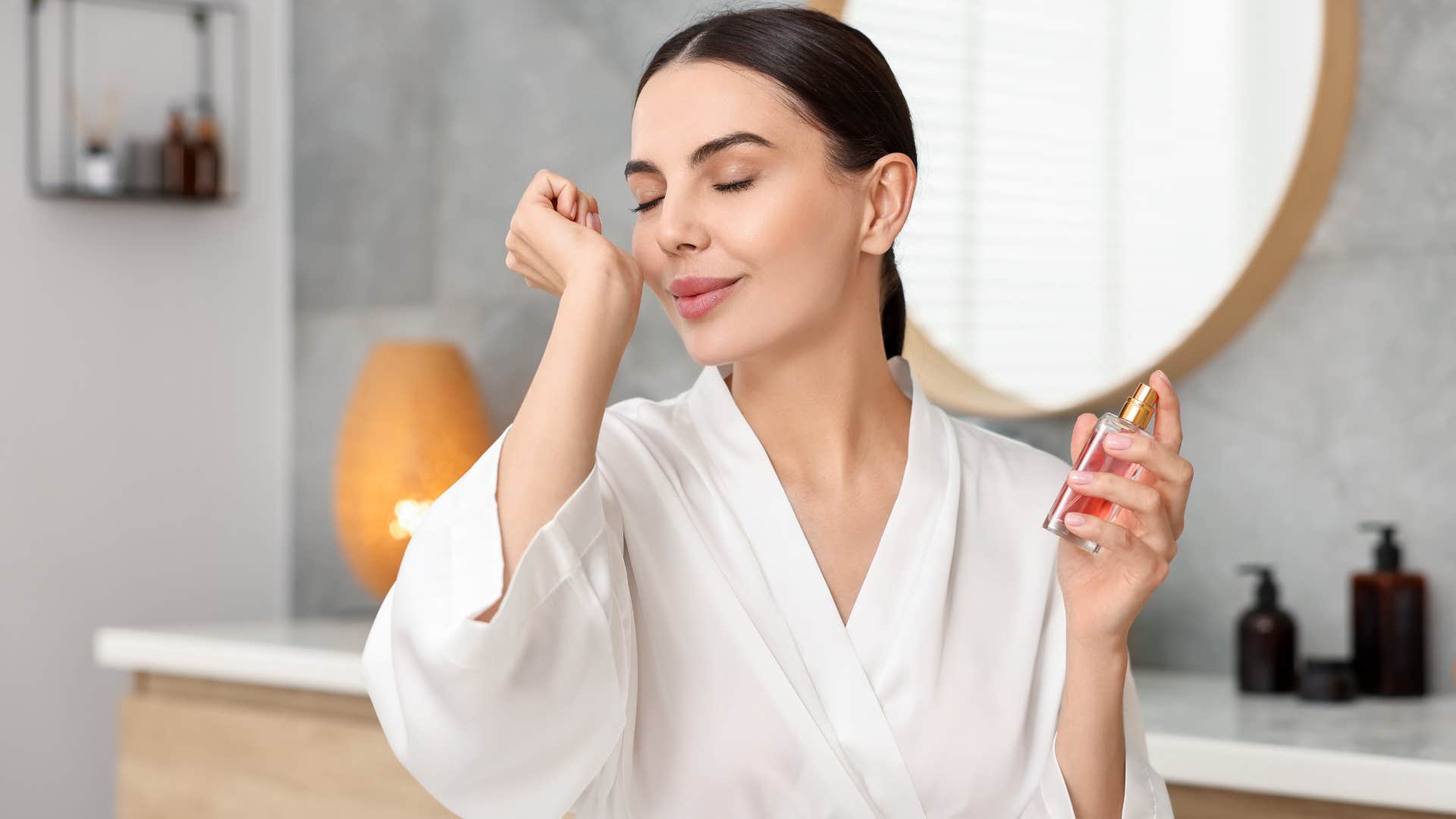 woman smiling wearing expensive perfume and sniffing her wrist