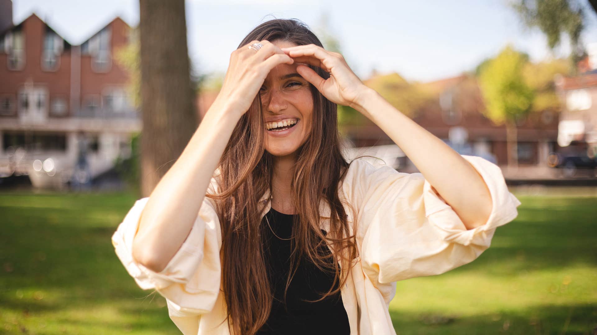 woman fixing her hair smiling