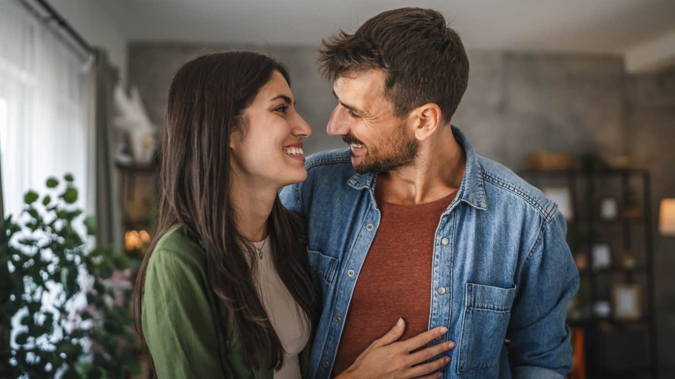 Subtle Body Language Clues That Are Obvious When Someone Is In Soulmate-Level Love, According To Psychology happy smiling couple with soulmate-level body language