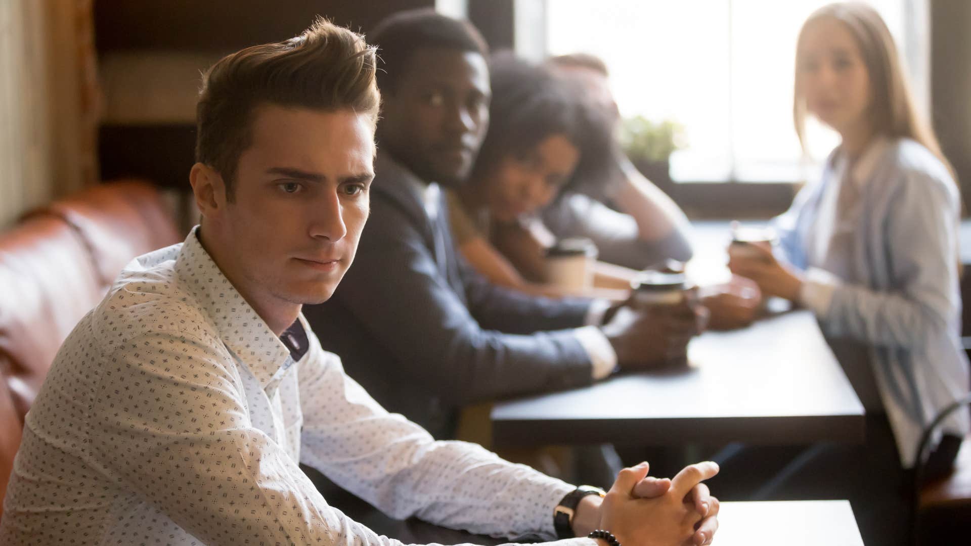 group of people giving subtle clues by never inviting man to social gathering