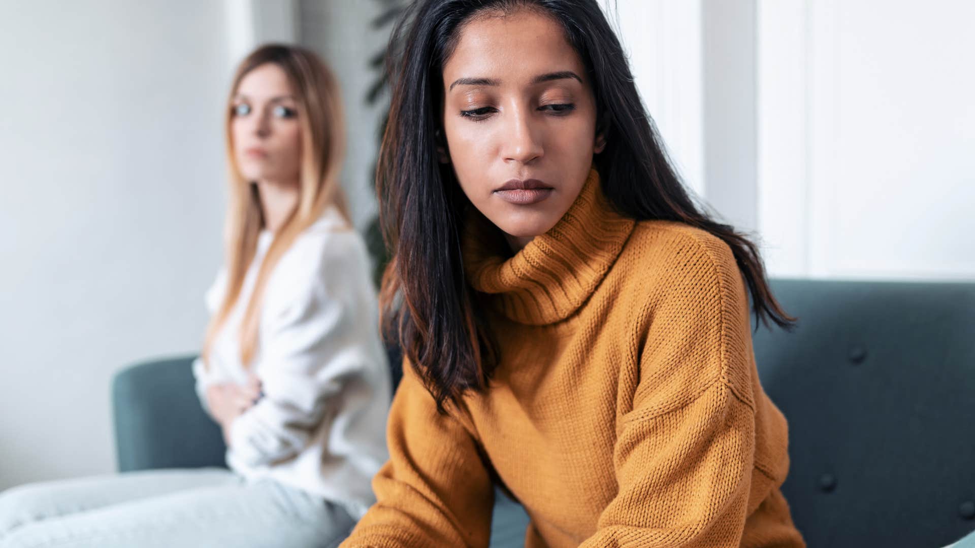 Woman disguising rudeness for honesty turned away from a friend.