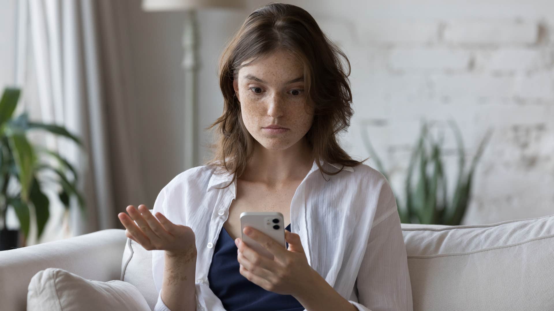 woman in black shirt in disbelief as her ex refuses to delete old photos of her online