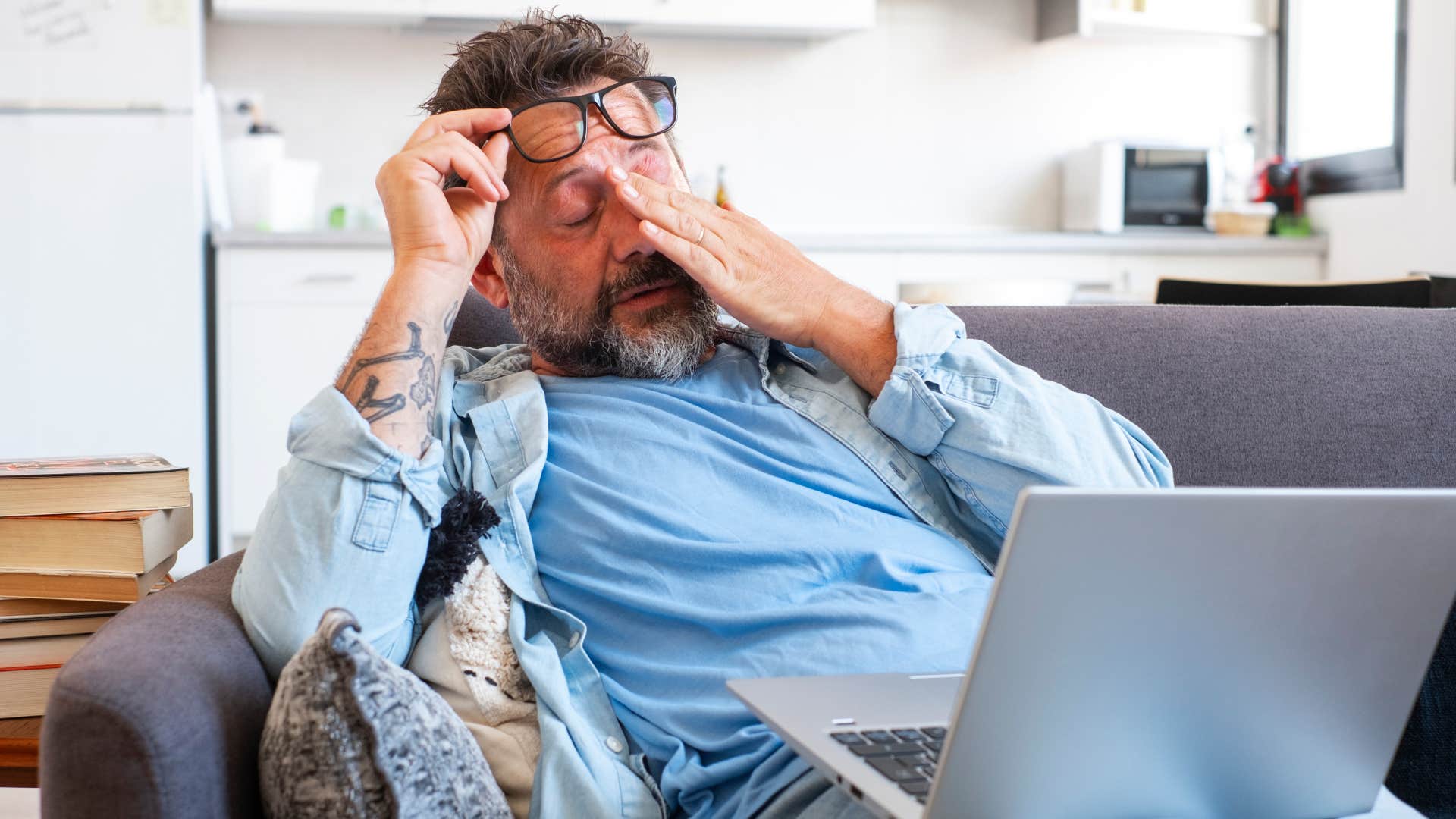 man rubbing his eyes not feeling calm