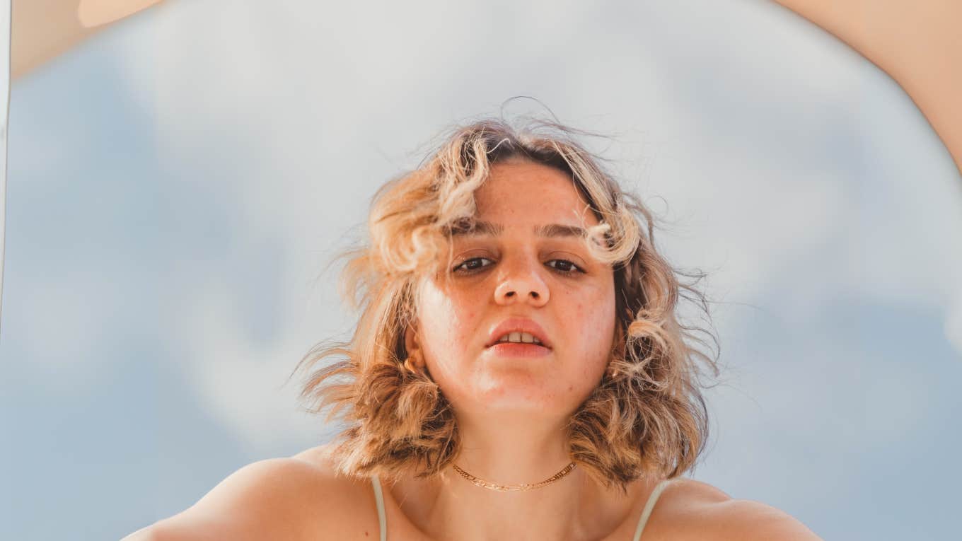 Woman looking into a mirror that is sabotaging her confidence. 