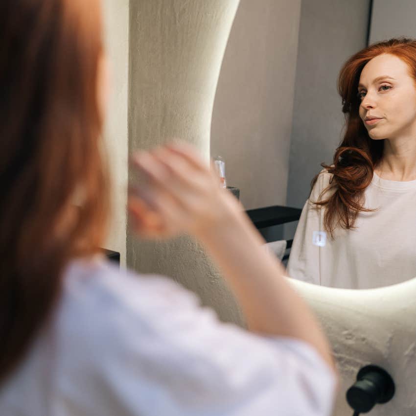 woman looking at herself in mirror
