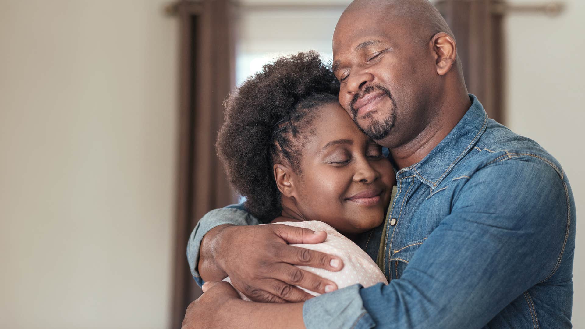 man hugging his wife while being celebrated for his success