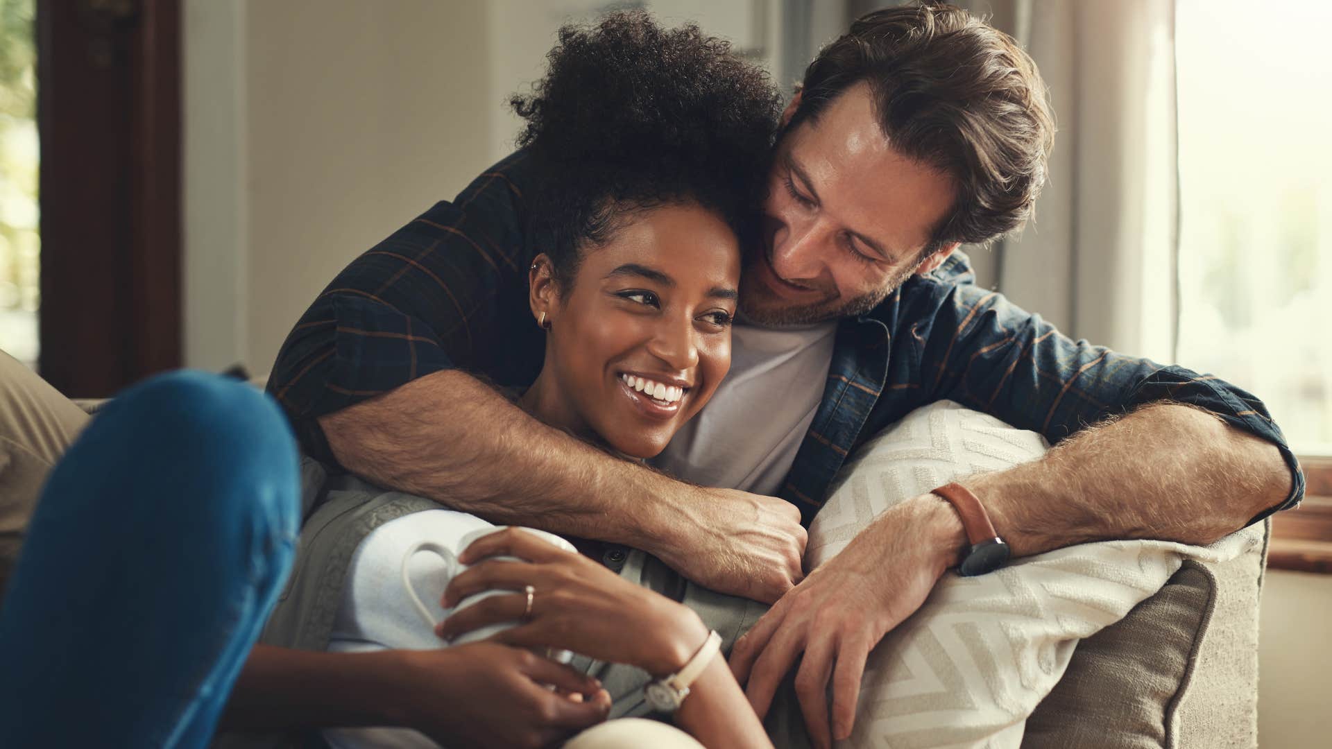 man hugging his wife enjoying consistency in their relationship
