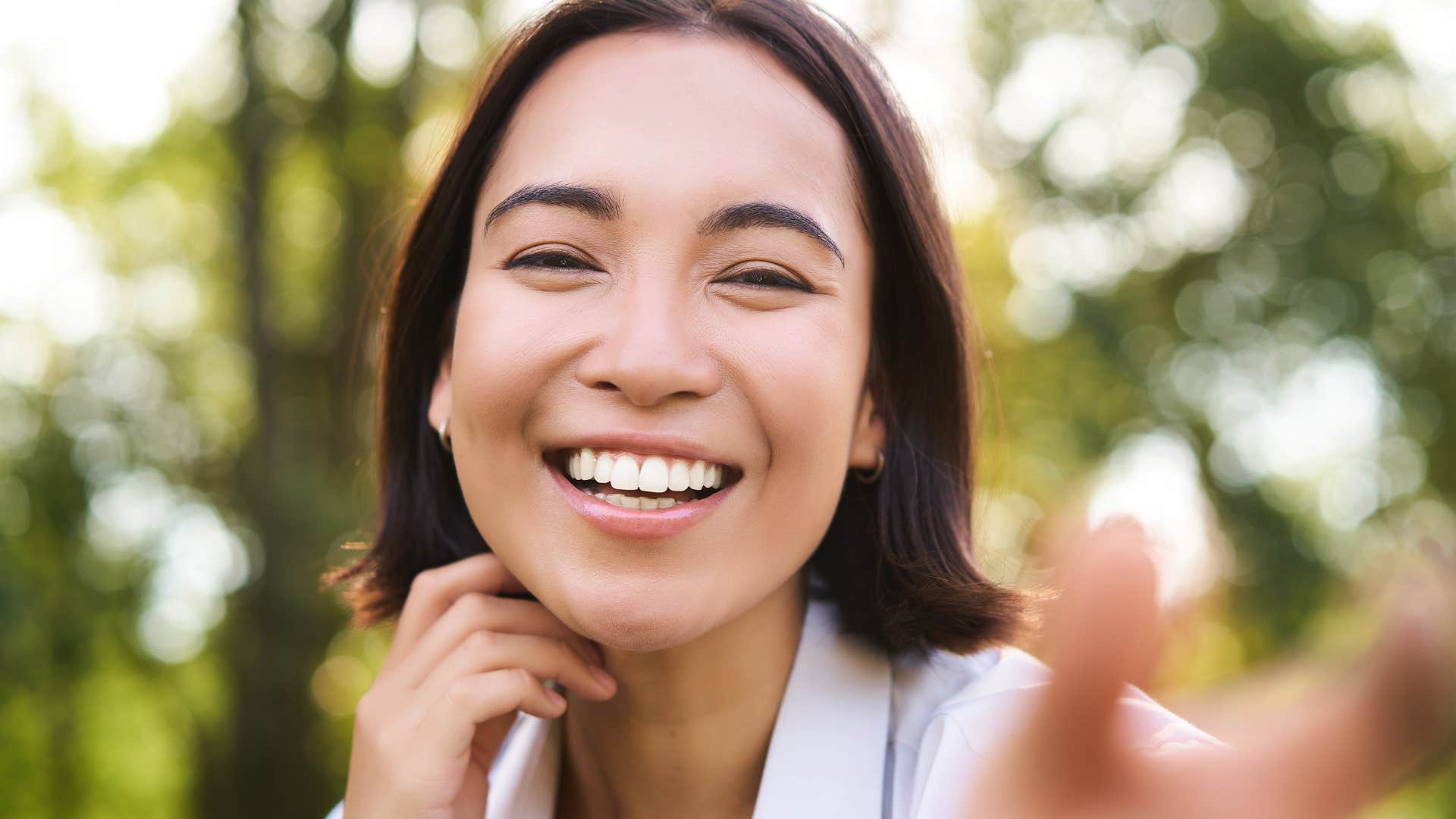 Woman with over-the-top positivity smiling at the camera.