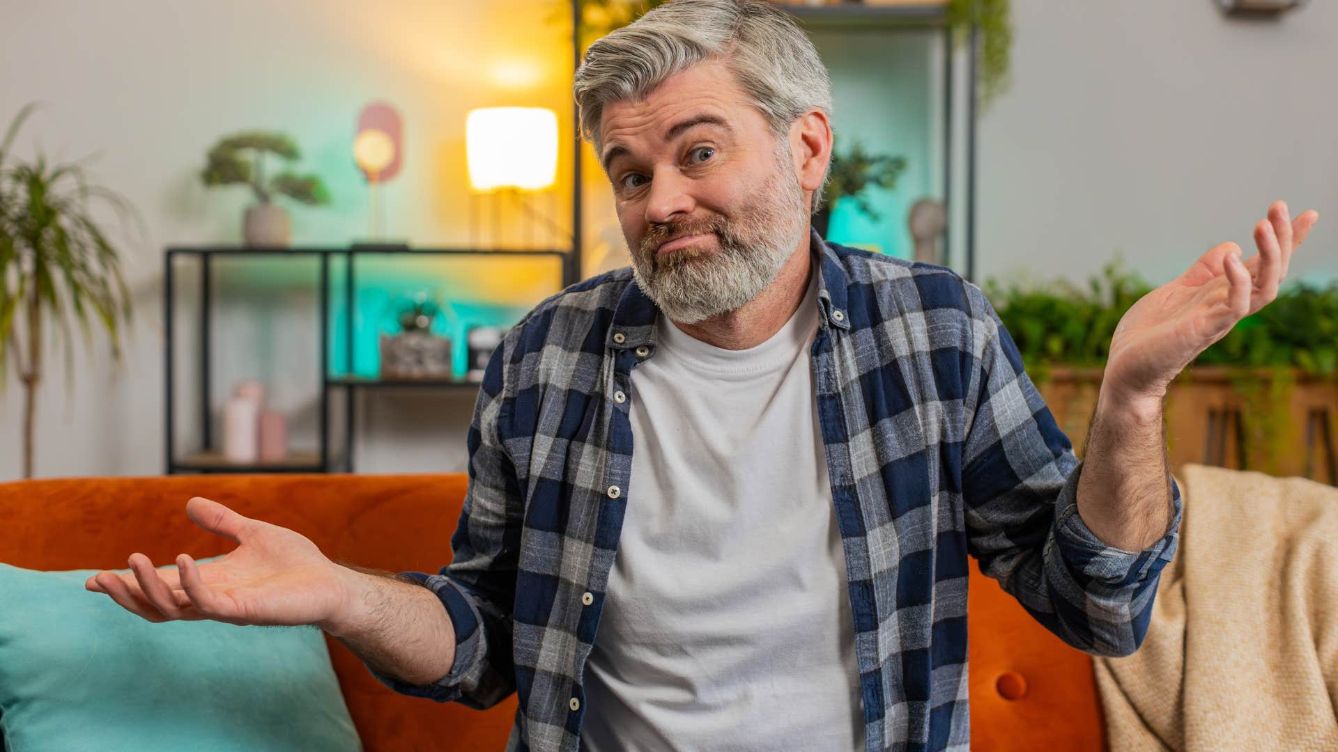 Man making jokes that rely on stereotypes or cheap shots shrugging at the camera.