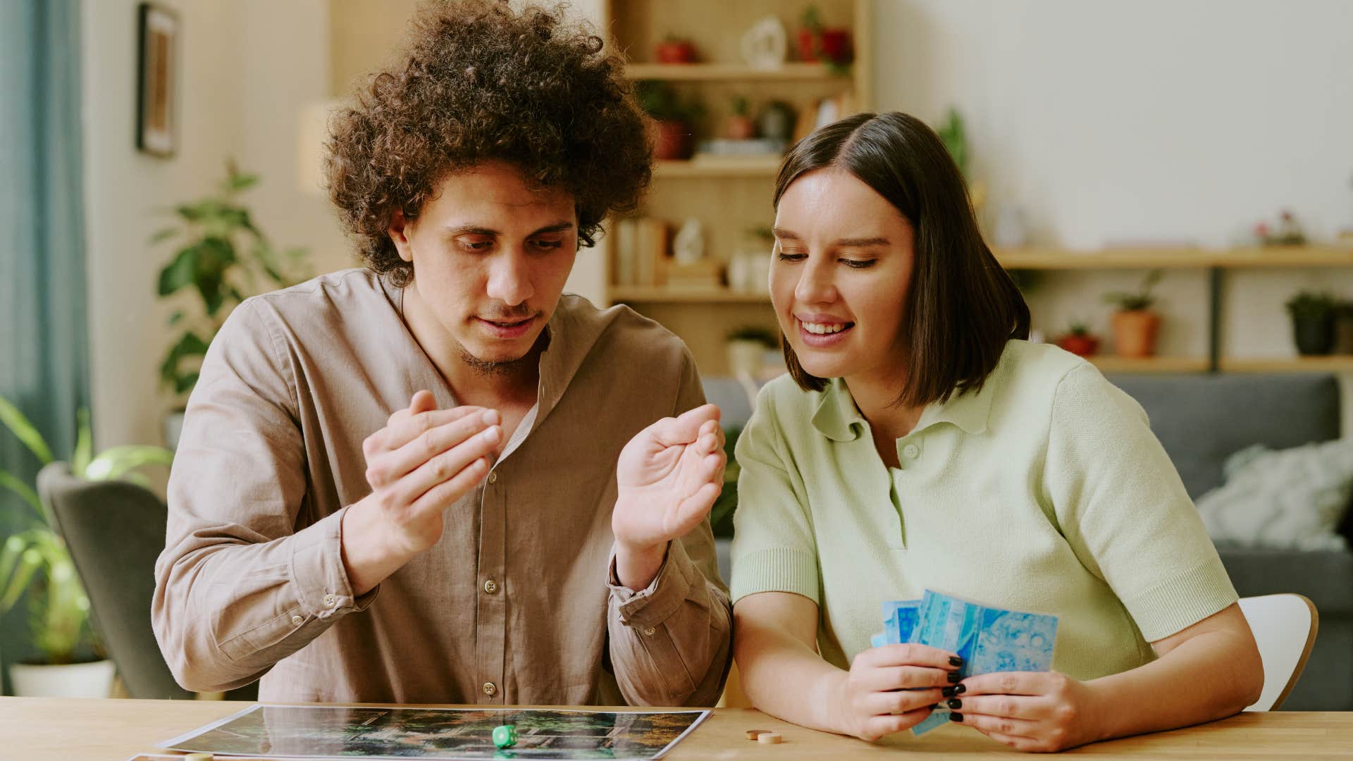 Man and woman smiling and playing games that rely on dumb luck 