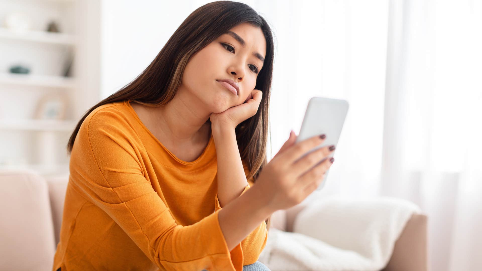 Bored woman binge-watching brainless shows doomscrolling on her phone for mindless entertainment