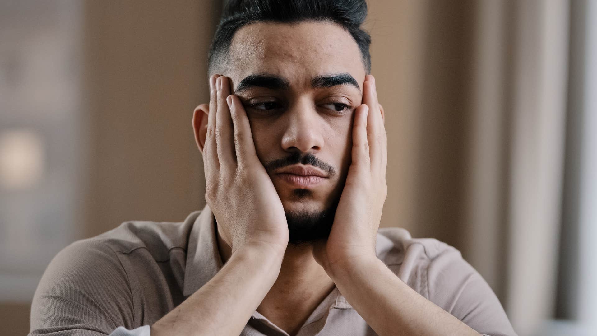 Man thinking about playing it safe and never taking risks and holding his face in his hands