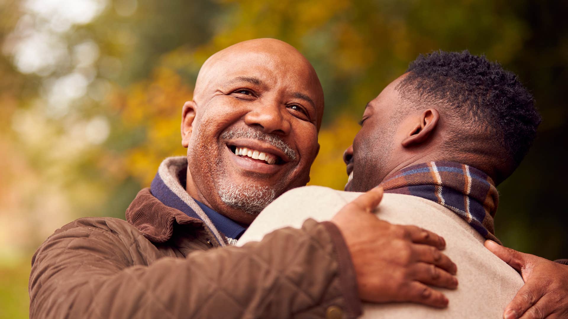 dad hugging adult son outside