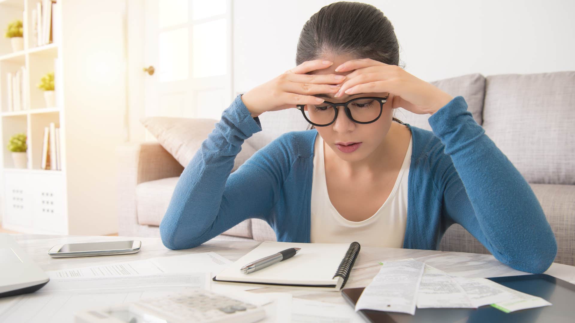 Gen Z woman thinking about saving money while doing bills