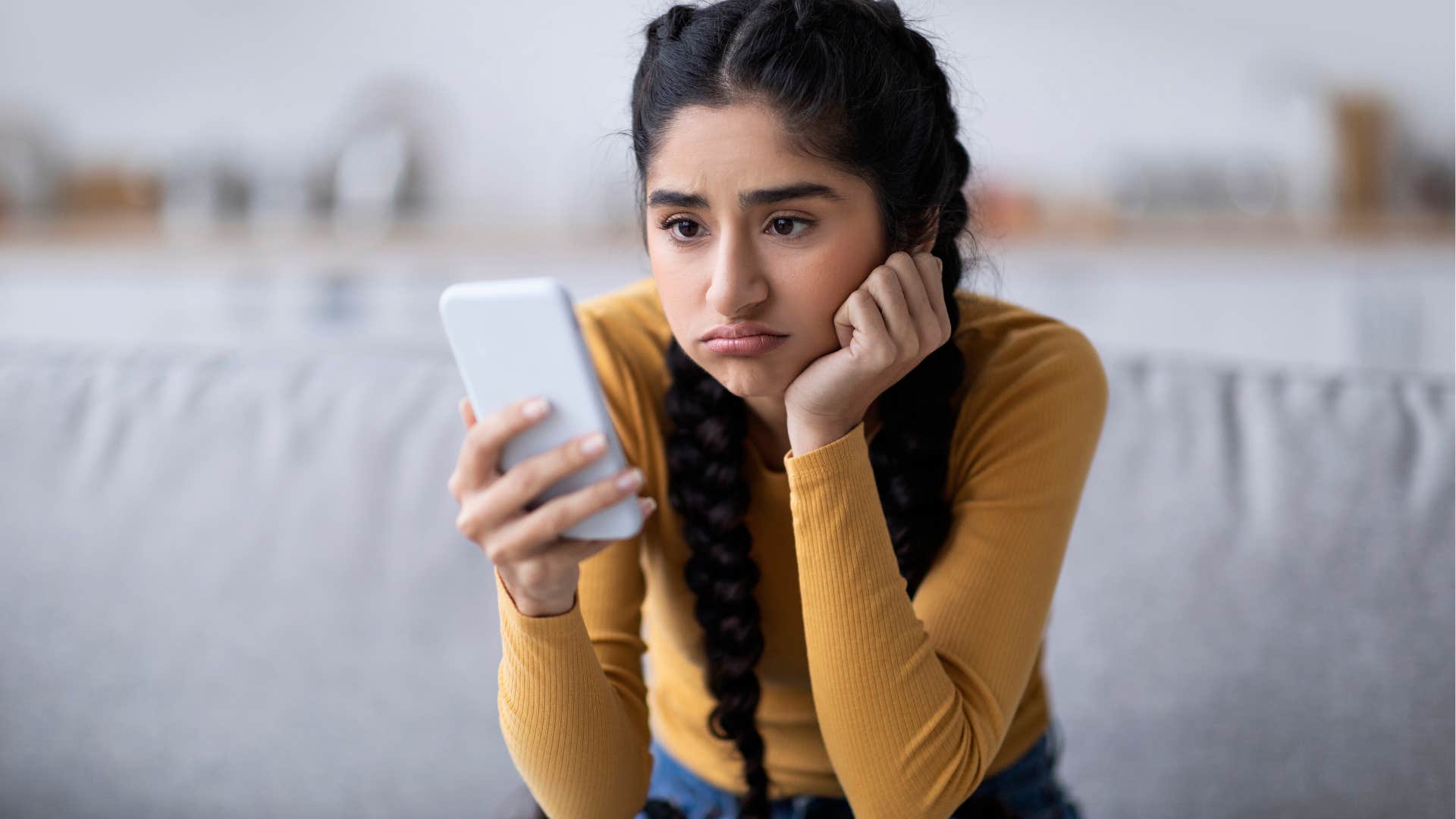 upset woman looking at poor media representation on her phone