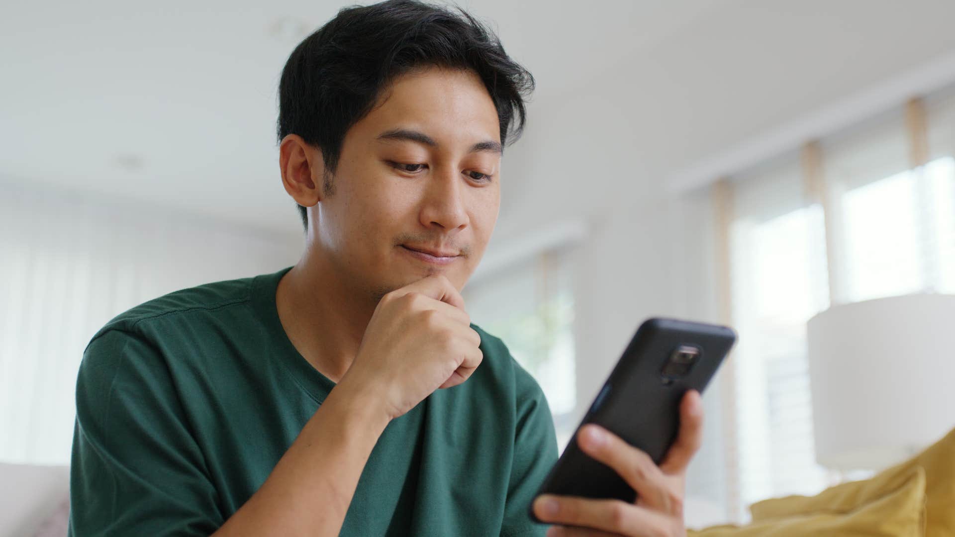 upset man thinking about unethical consumerism scrolling on phone