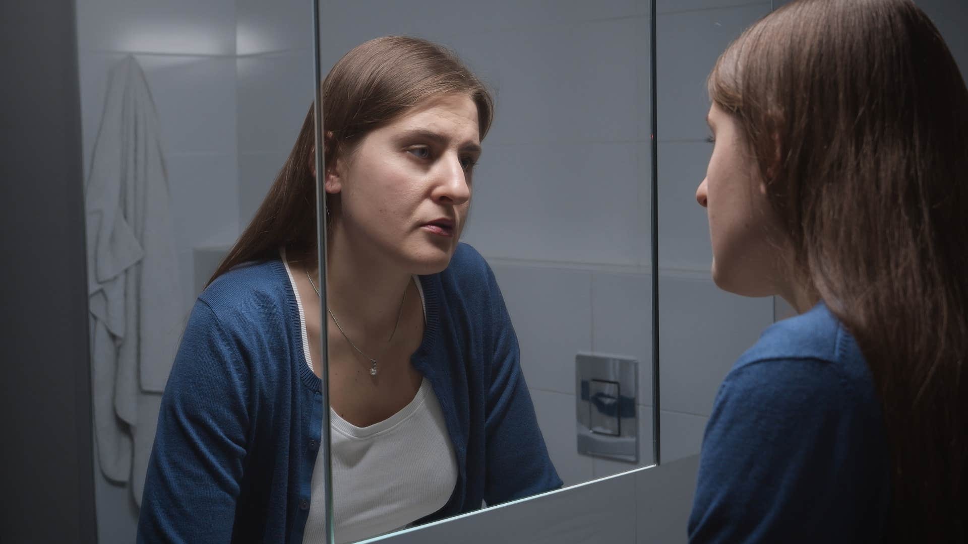 gen z woman with body image struggles looking in the mirror