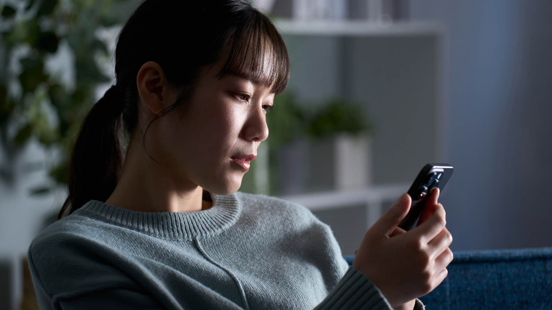 gen z woman scrolling on social media at home