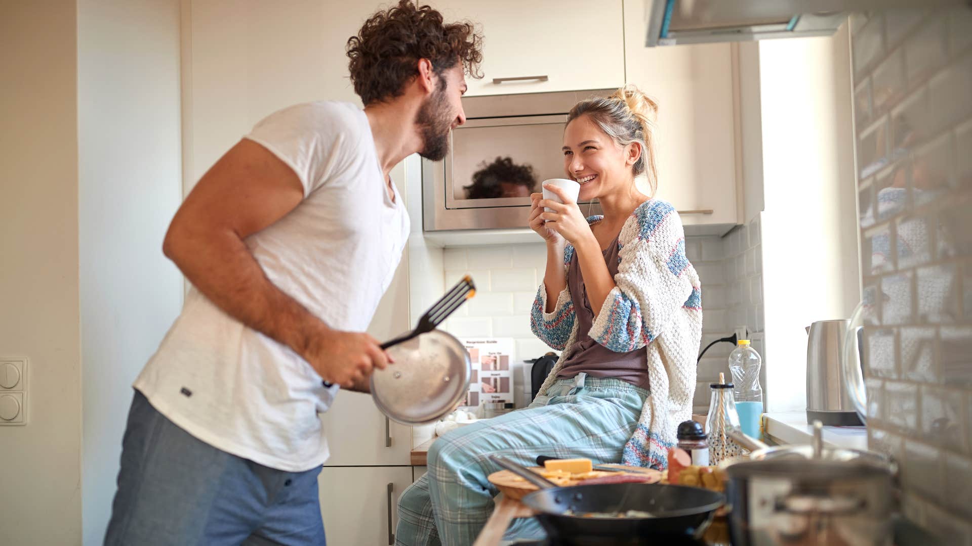 man cooking dinner for happy woman