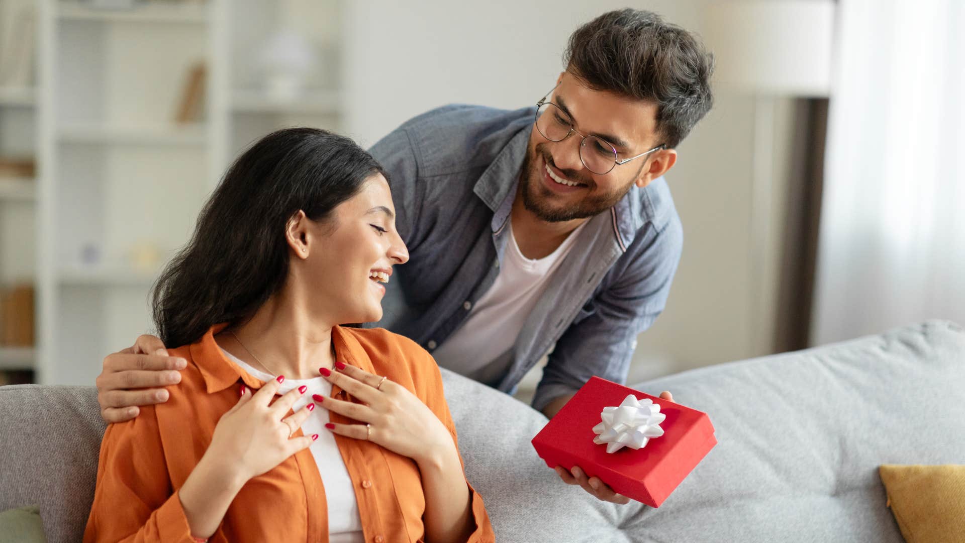 generous man surprising woman with a gift