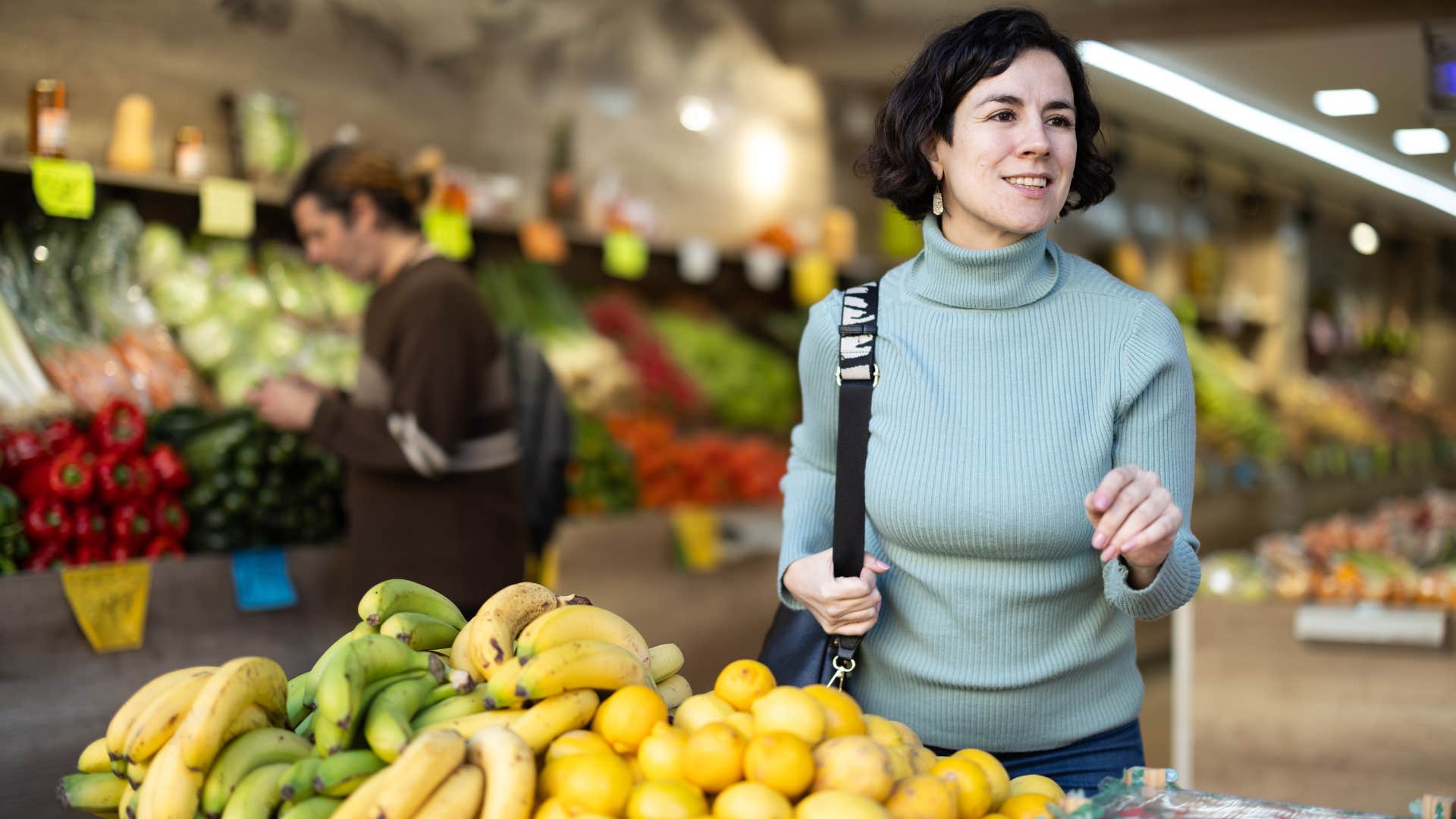 mother in blue shirt grocery shopping as she likes to keep her children's favorite snacks just in case