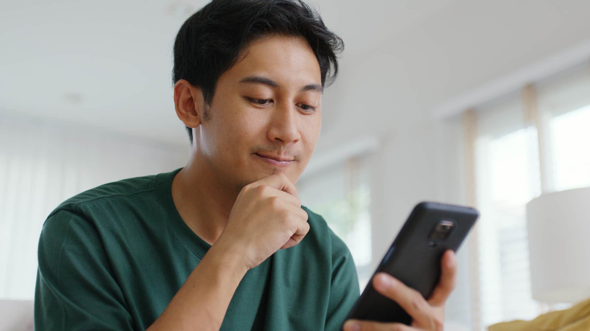 man scrolling on social media on his phone pretending to like it