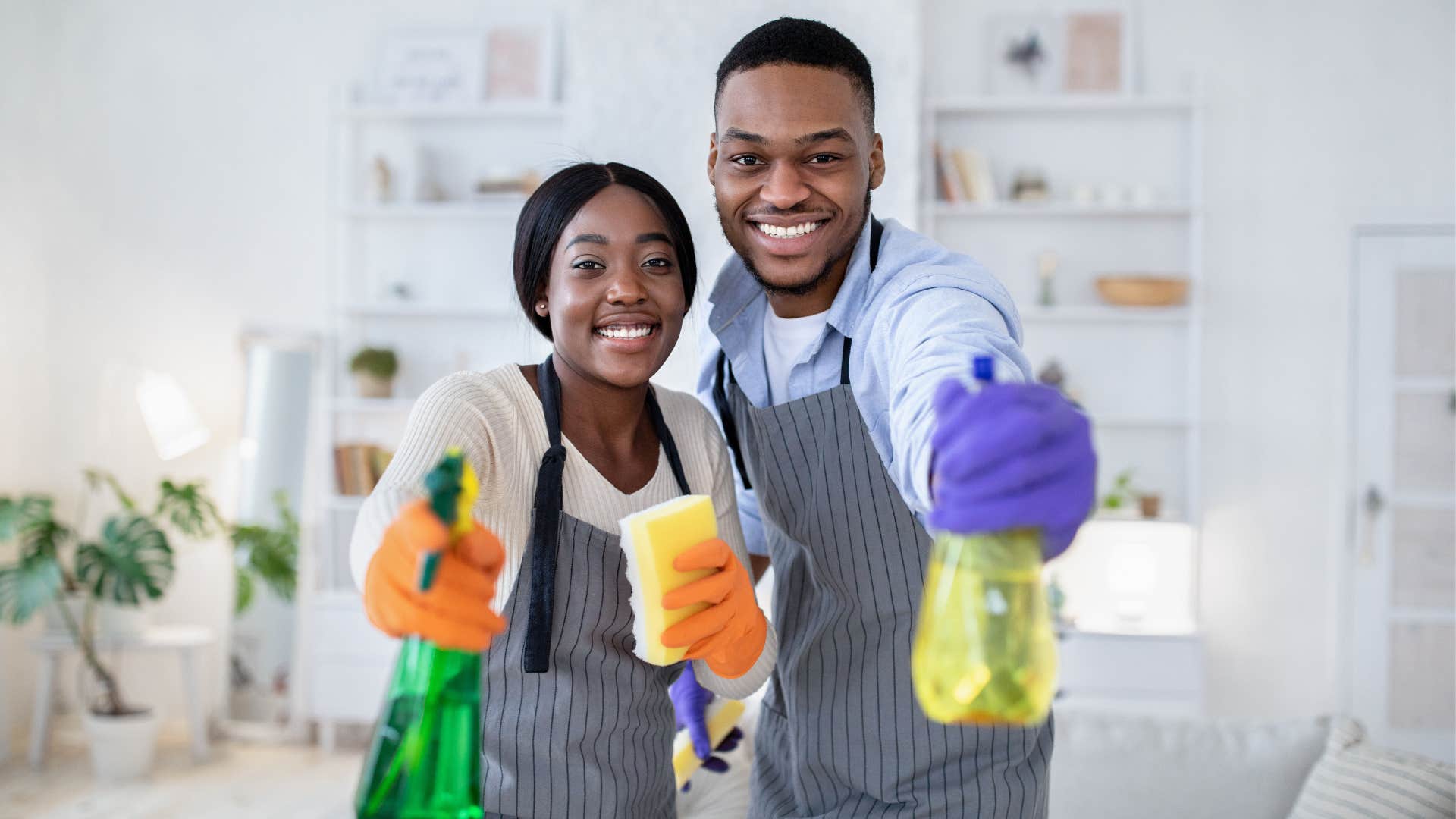 Happy couple with cleaning supplies was raised well
