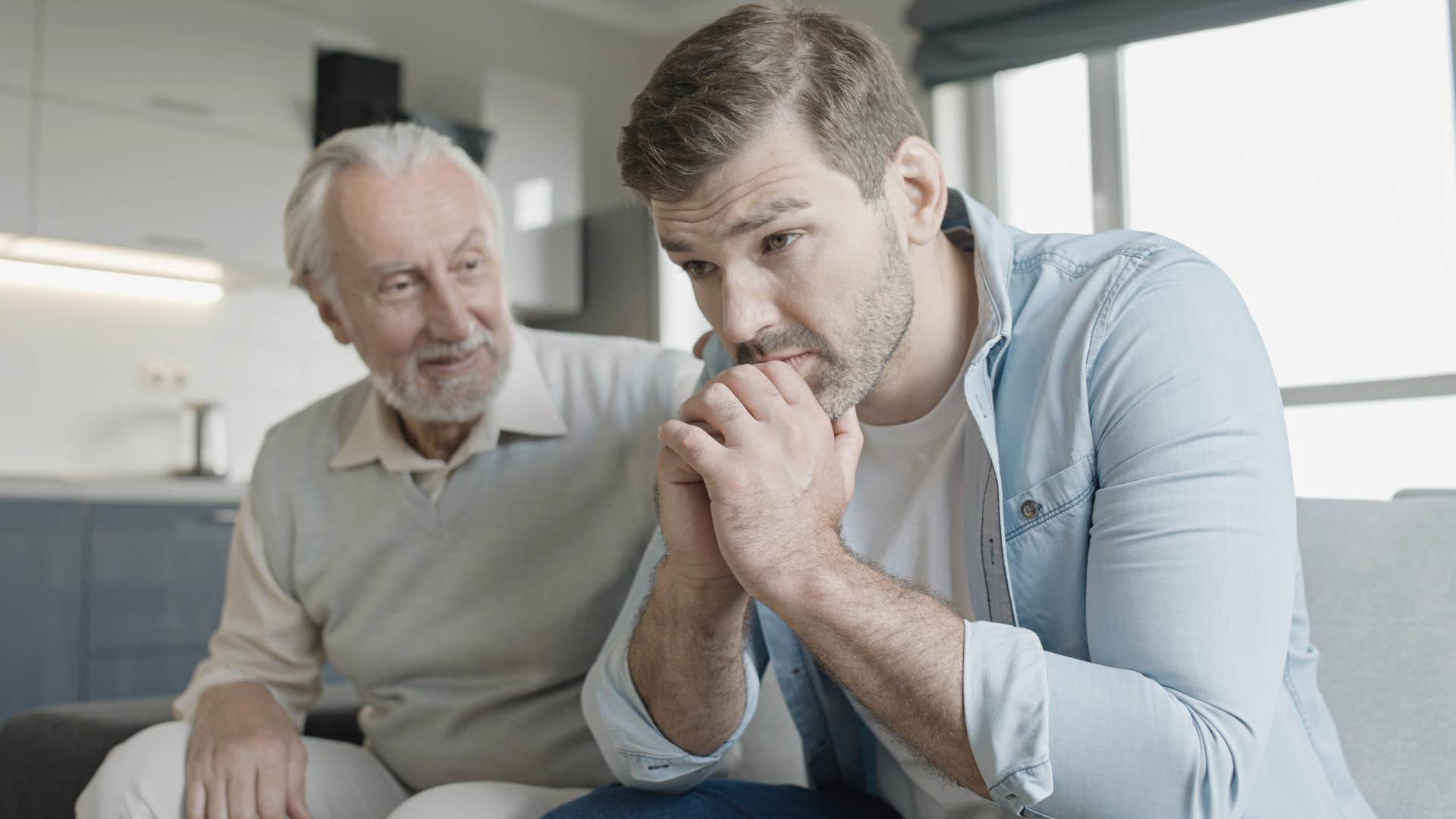 Man dismissing mental health next to his upset adult son.