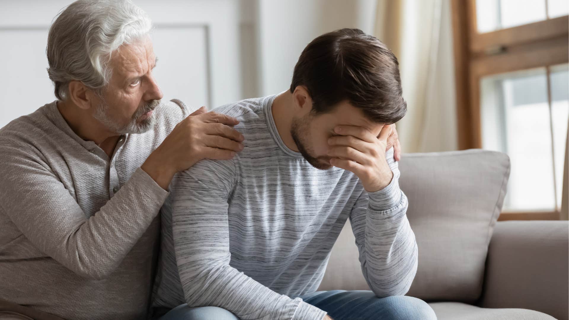 man comforting his adult son after judging his lifestyle