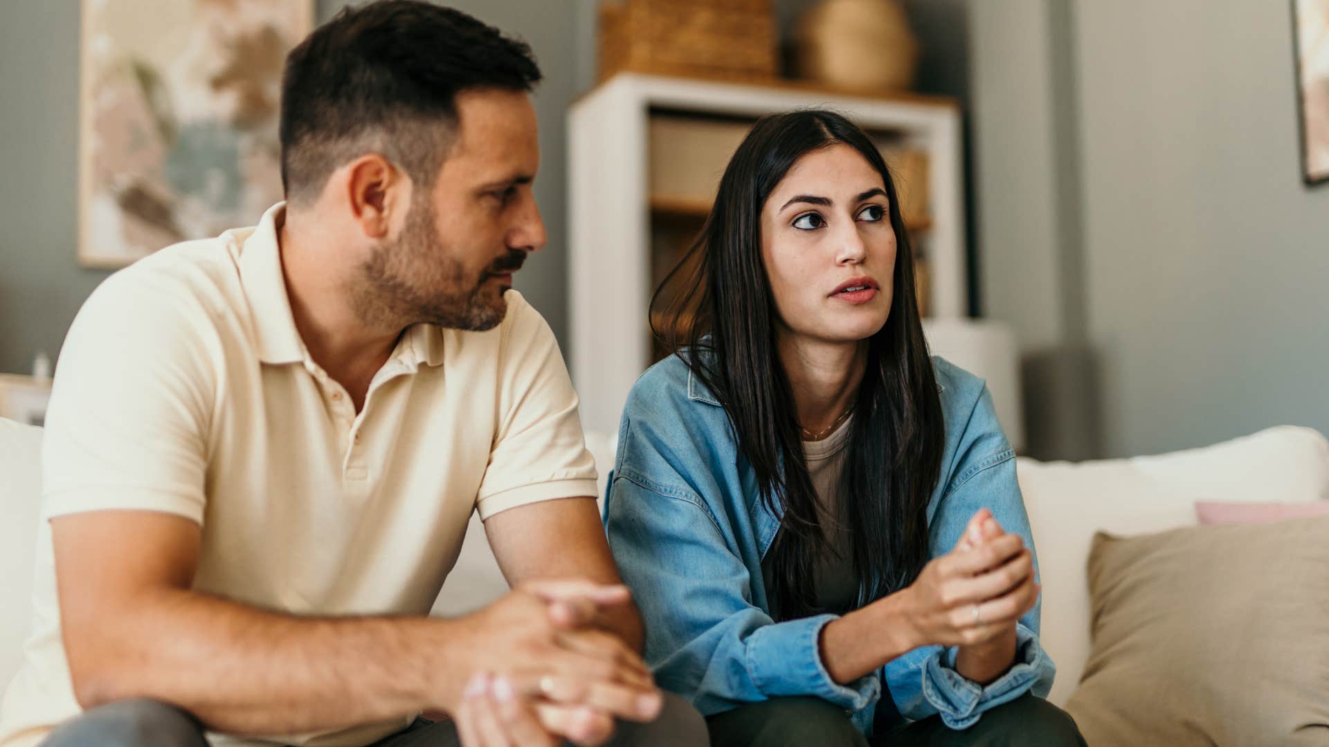 high iq man telling his upset wife bad jokes on the couch