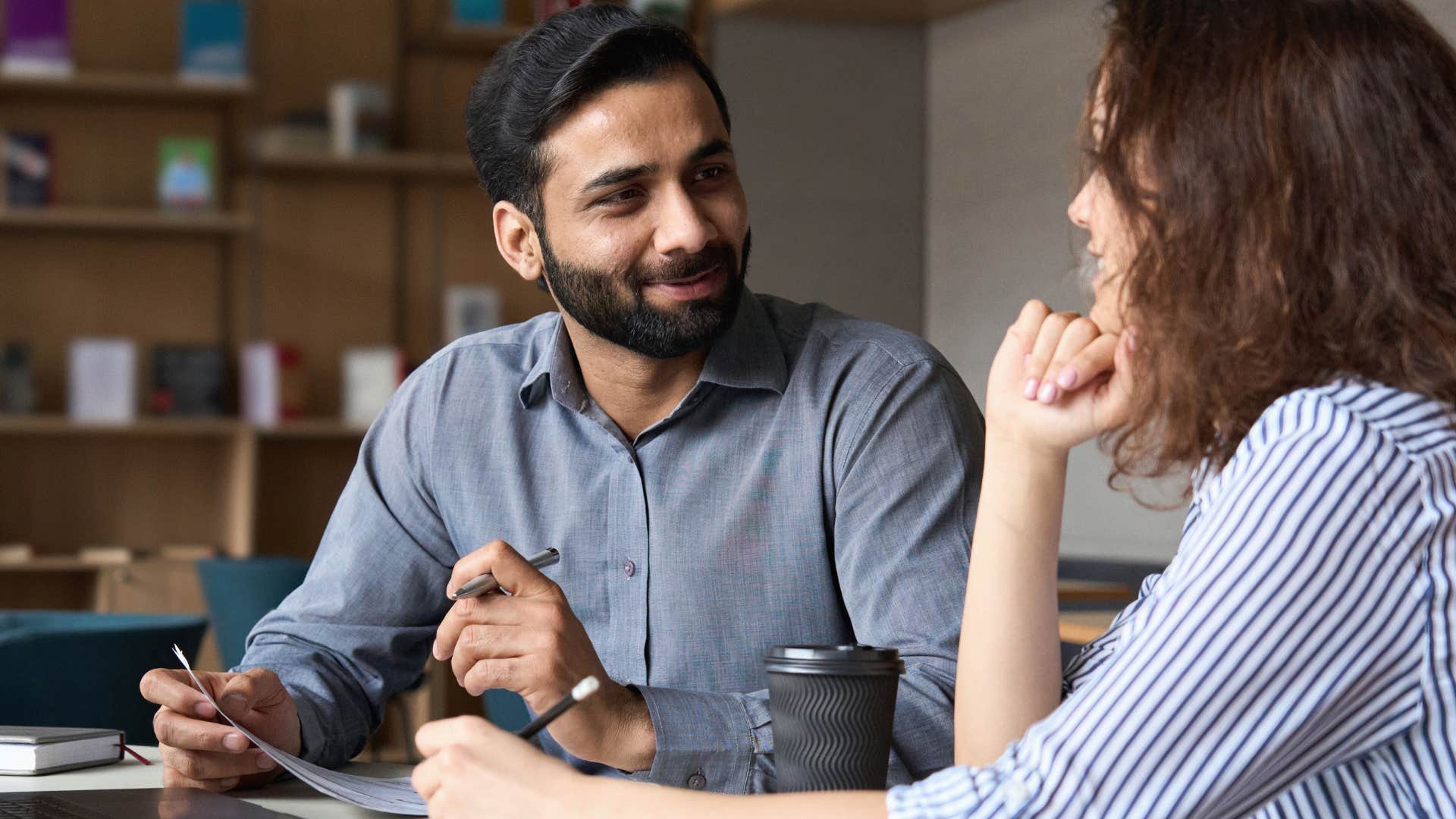 intelligent man pretending to enjoy being the smart friend and talking to a woman