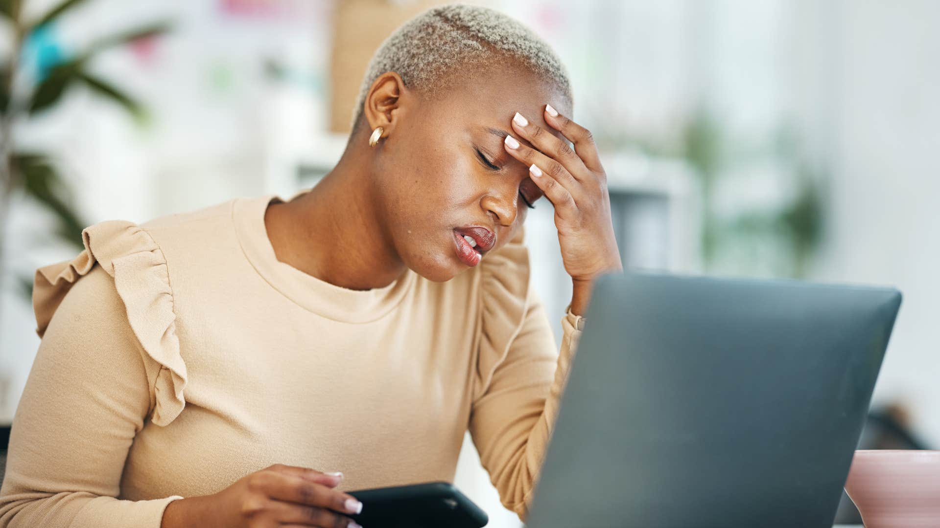 Overwhelmed woman looking at her laptop
