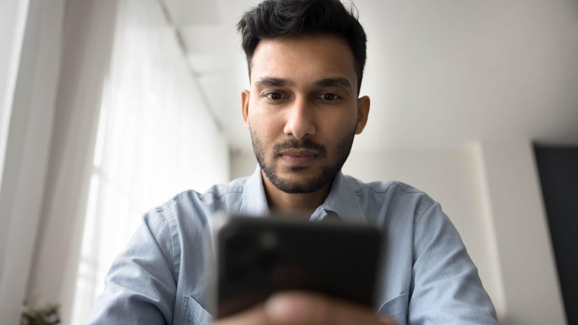 Gen Z man looking at influencer content on his phone