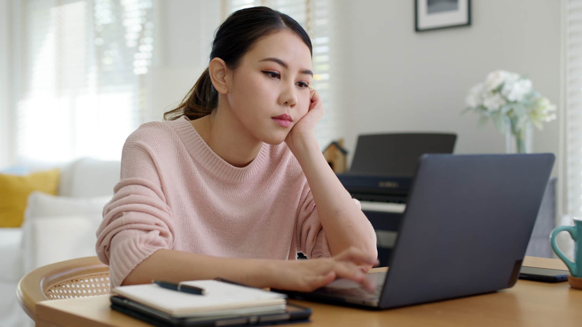 bored gen z woman sitting in pointless virtual work meetings