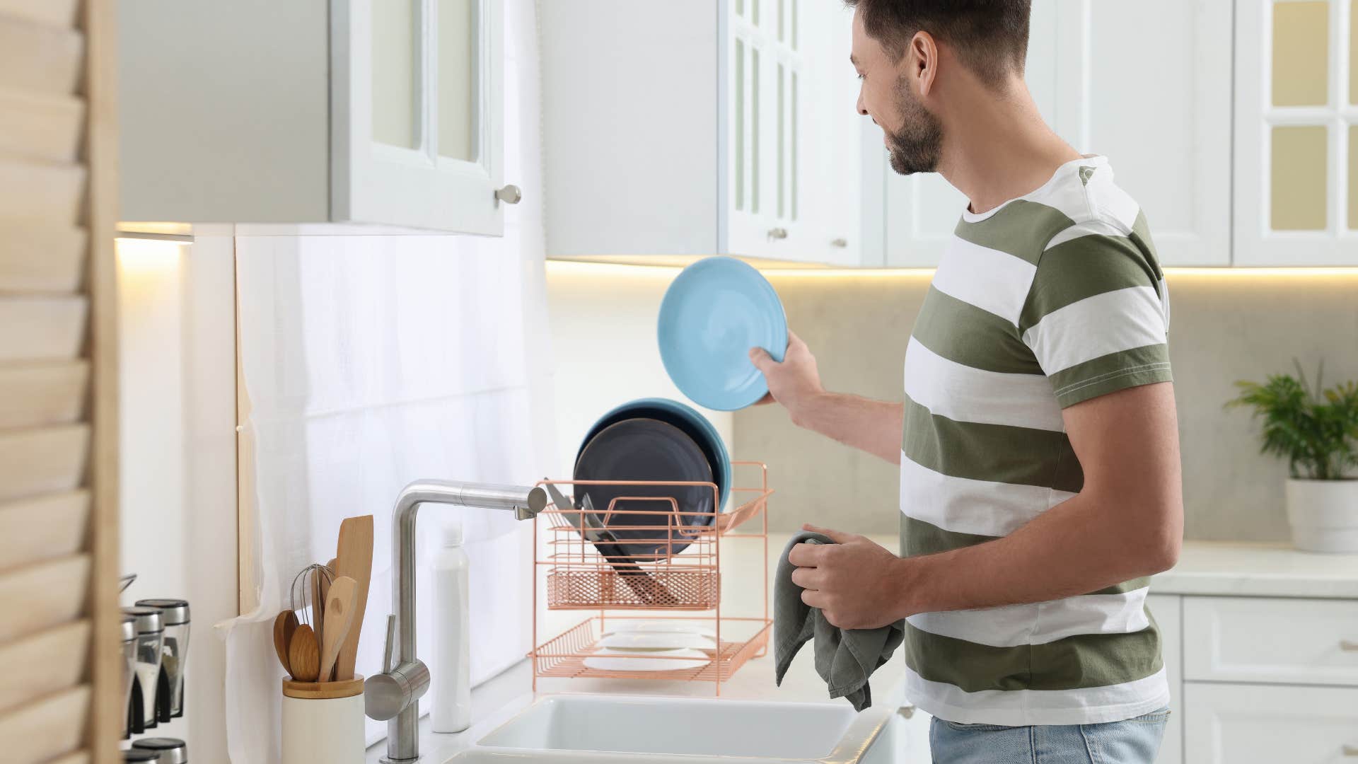 man putting dishes on dish rack cleaning dirty dishes