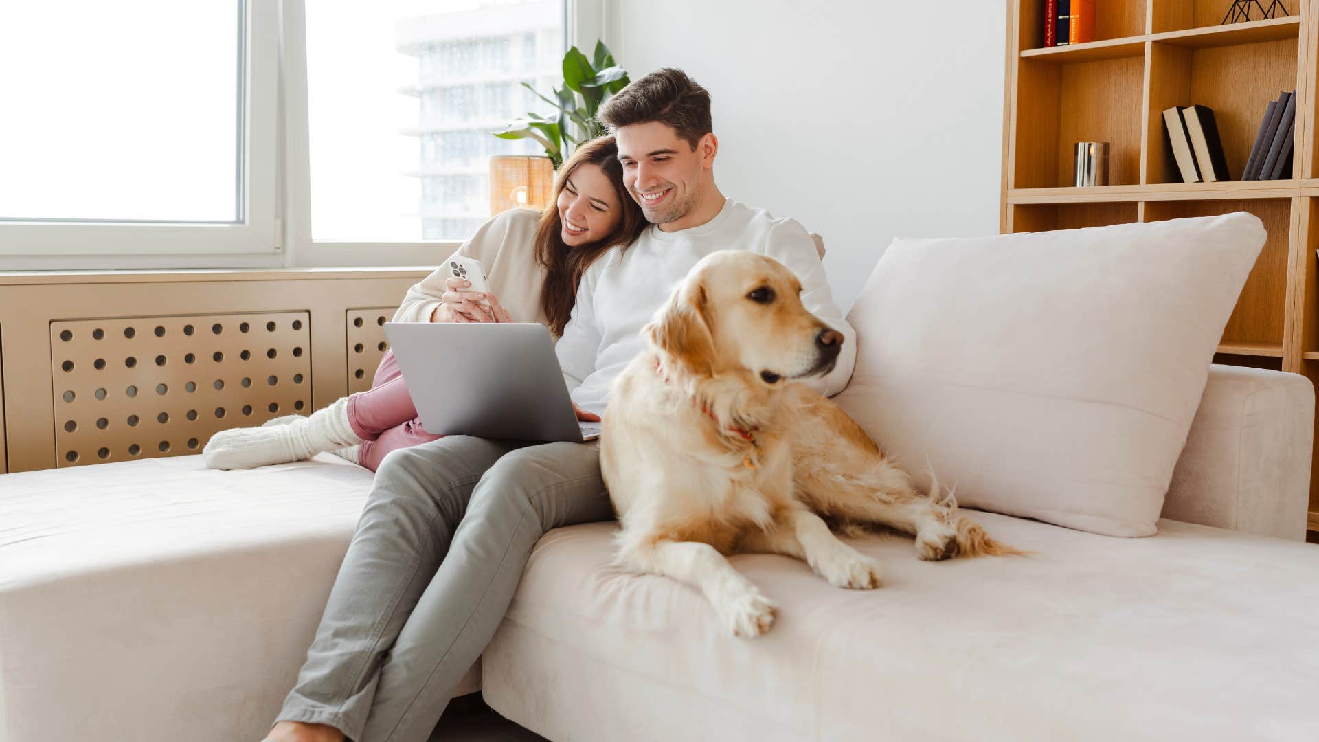couple sitting on furniture with dog pet hair everywhere