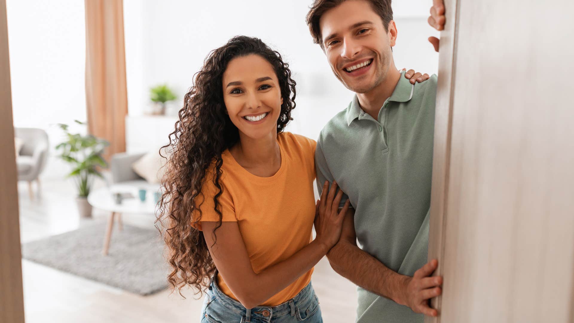 couple welcoming guest into home