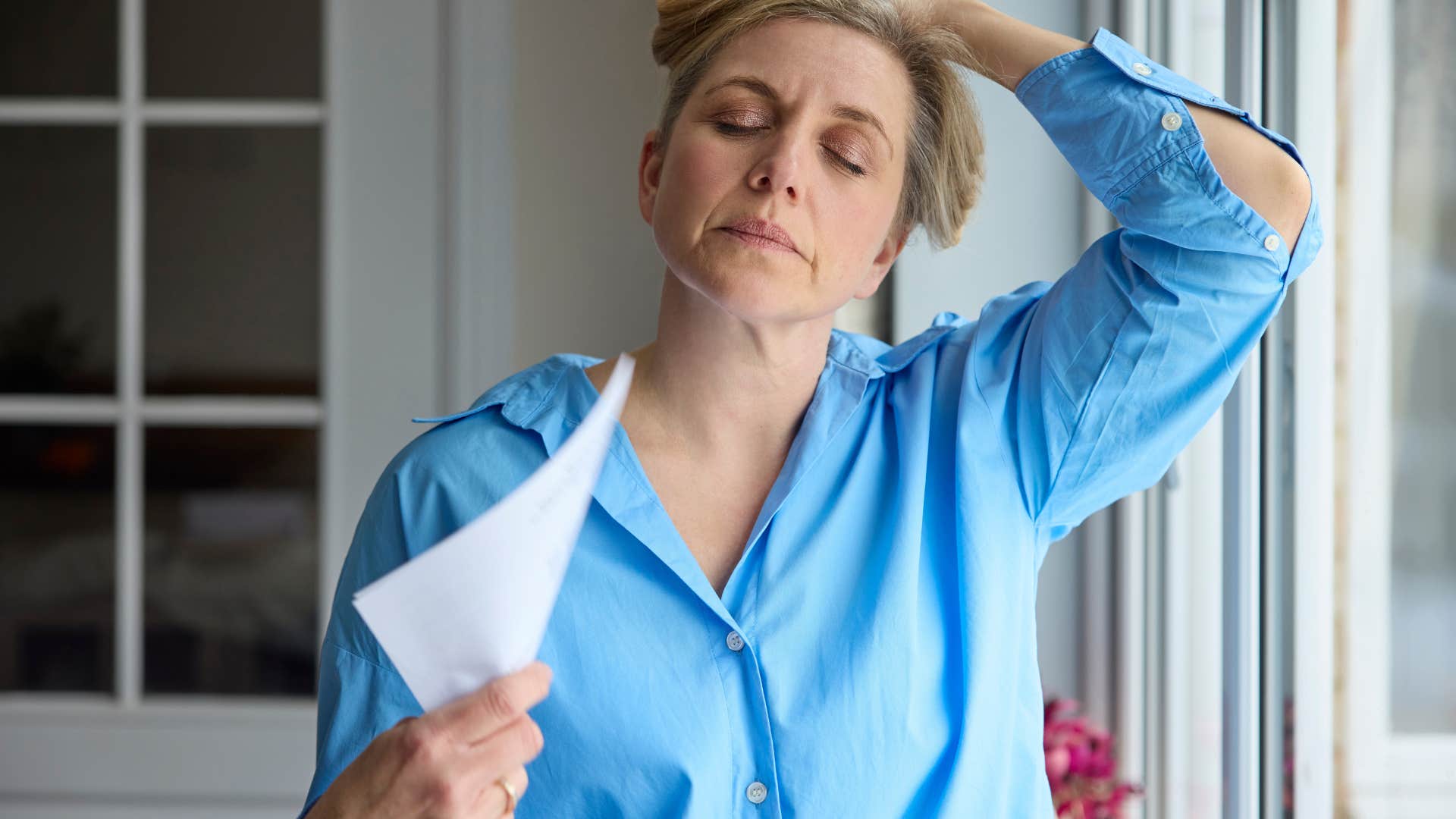 woman fanning herself because she's too hot