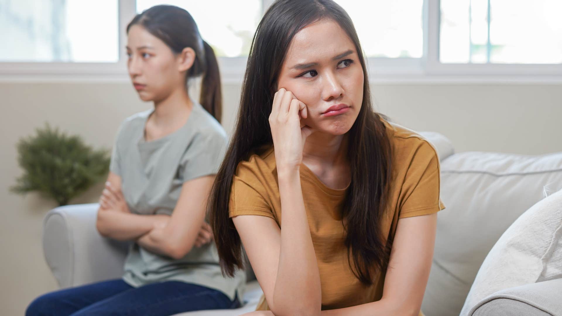 Woman turned away from her mother who's favoring siblings.
