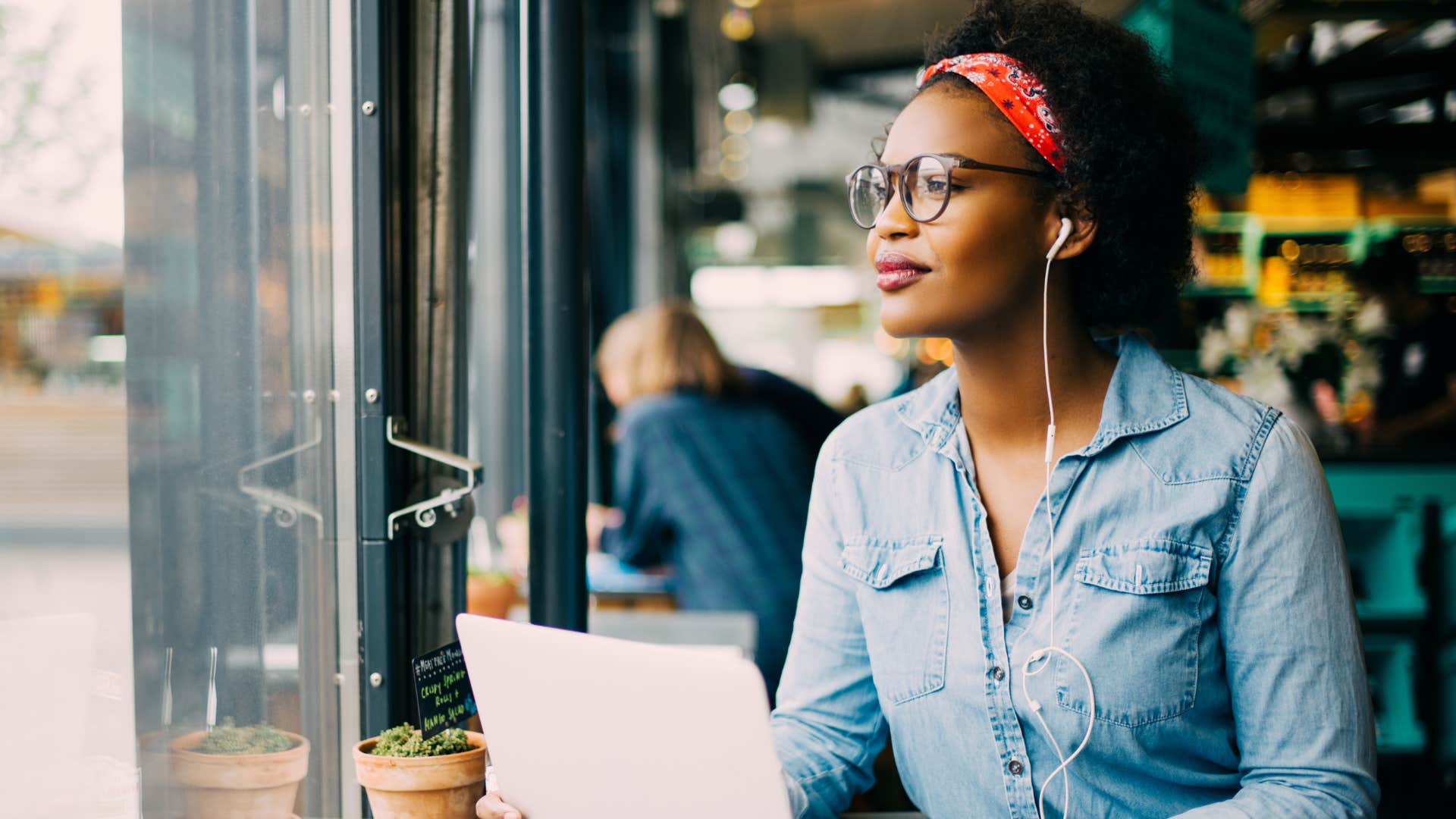 woman wearing headphones working at a cafe