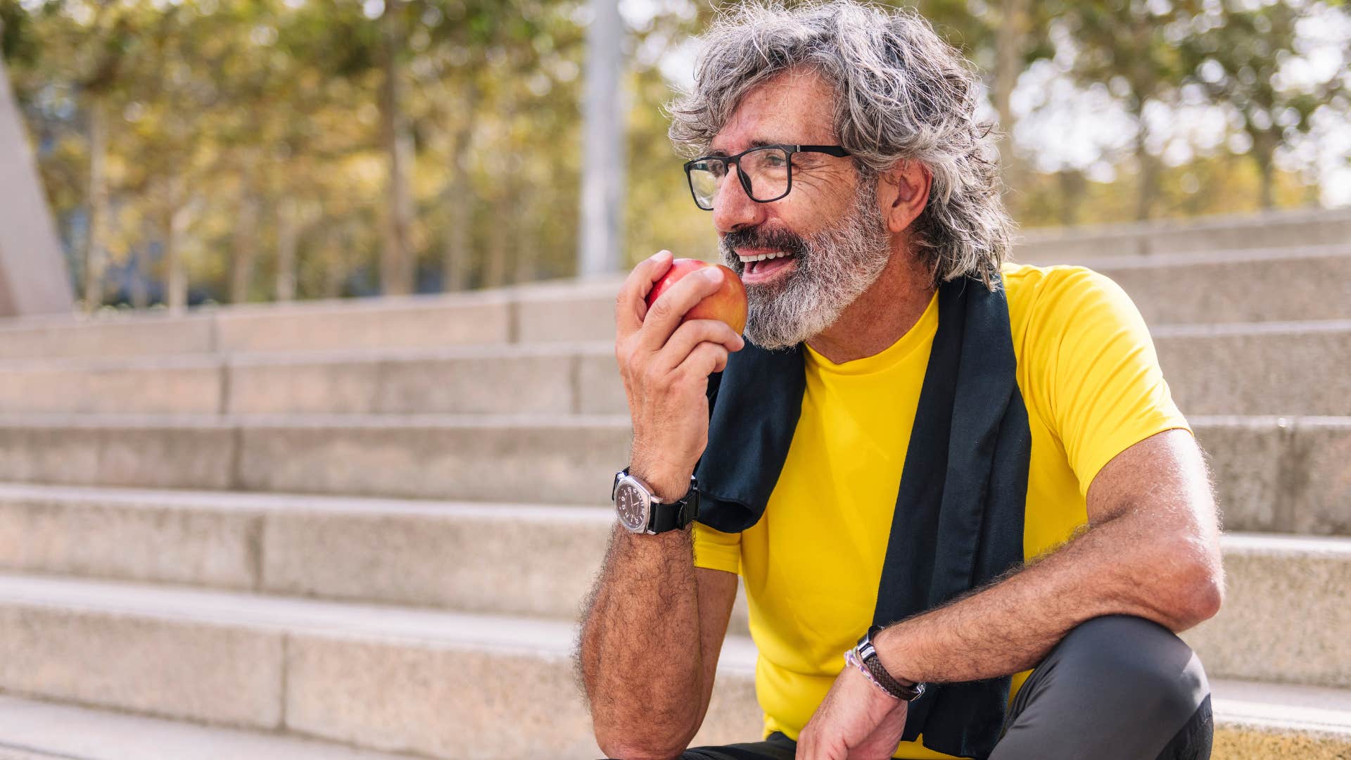 man eating a healthy apple outside