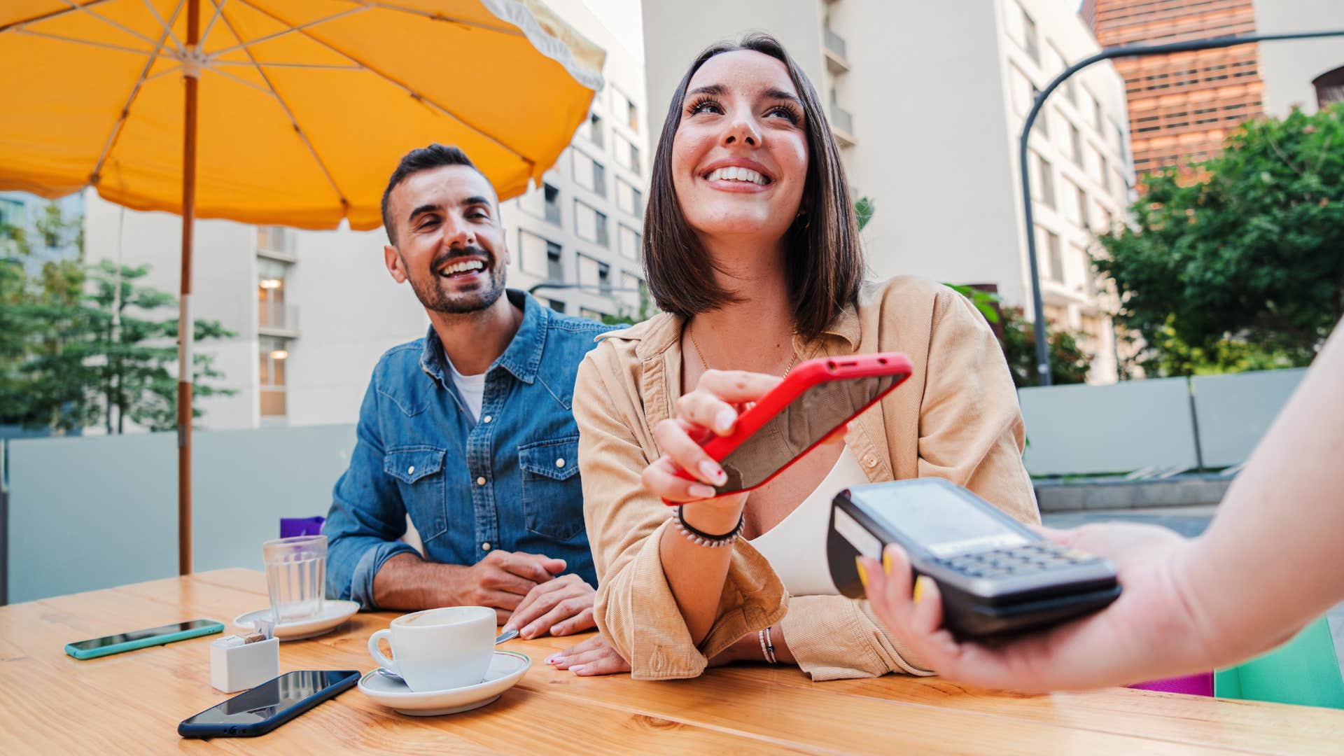 couple with woman paying the bill at restaurant