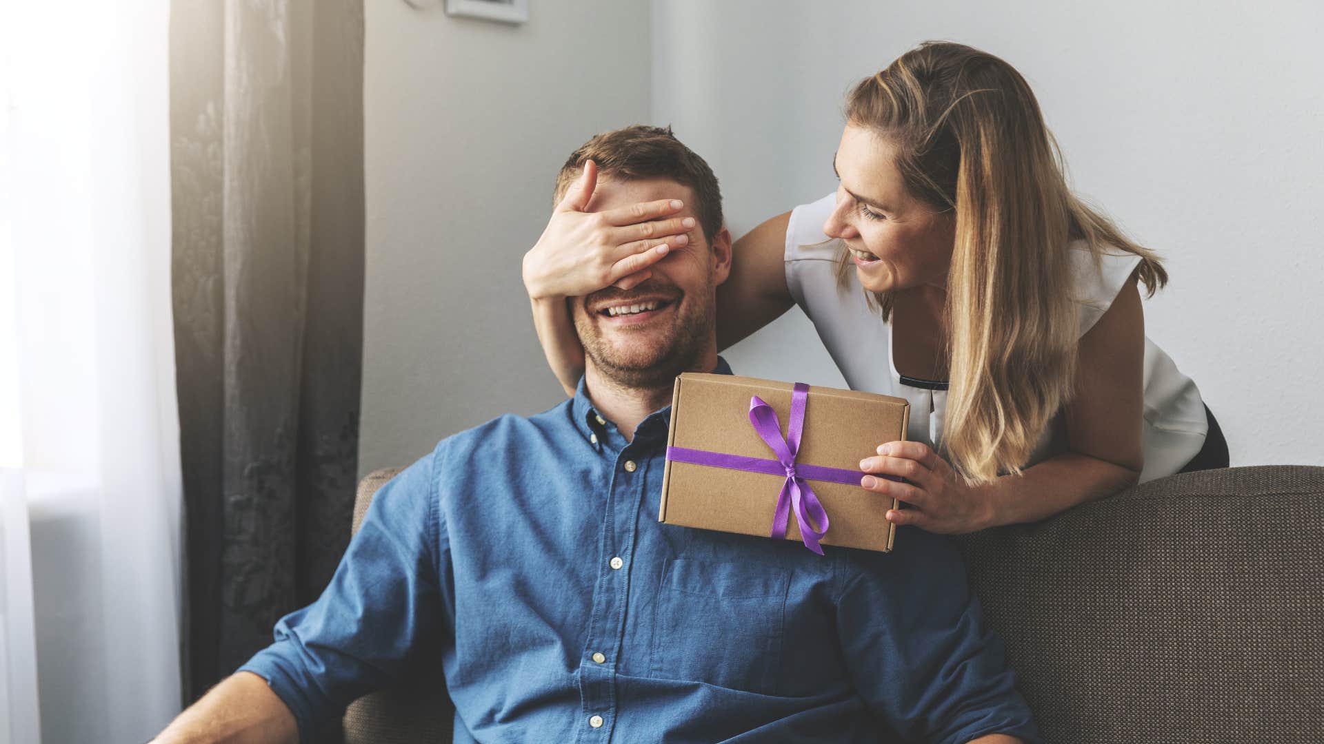 woman surprising man with a gift for no reason